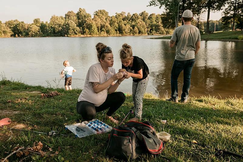 Harrell baits a fish hook with Ann in Madisonville, Ky., in June.